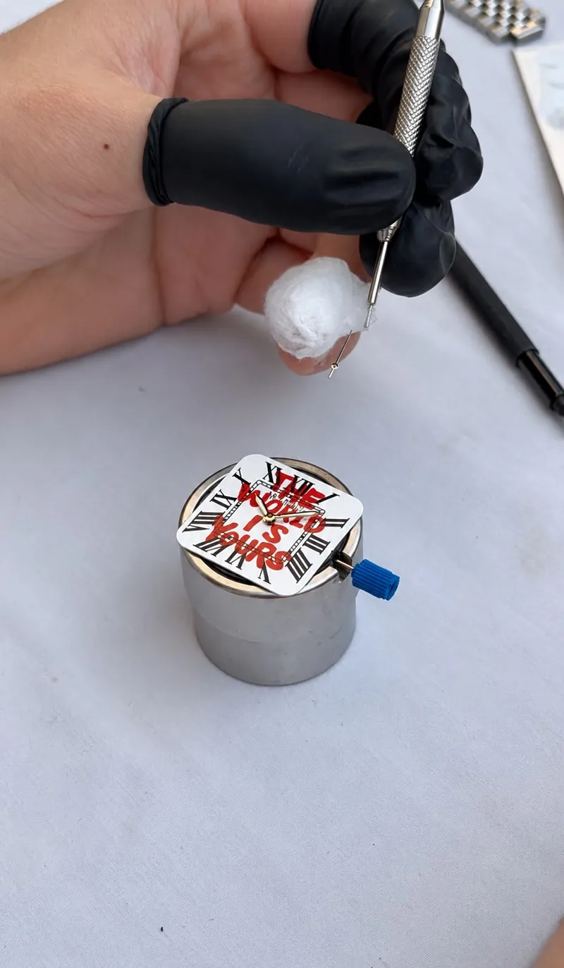 Pose des aiguilles sur un cadran, à l'atelier